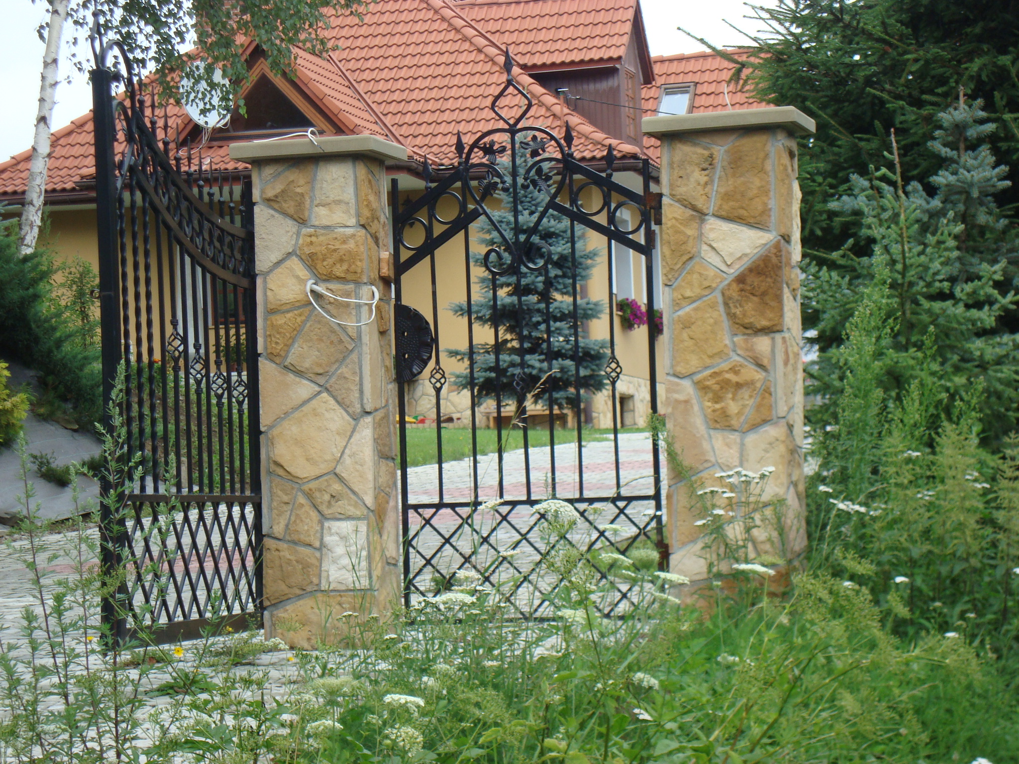 Ogrodzenie z kamienia polnego z okrągłymi słupkami